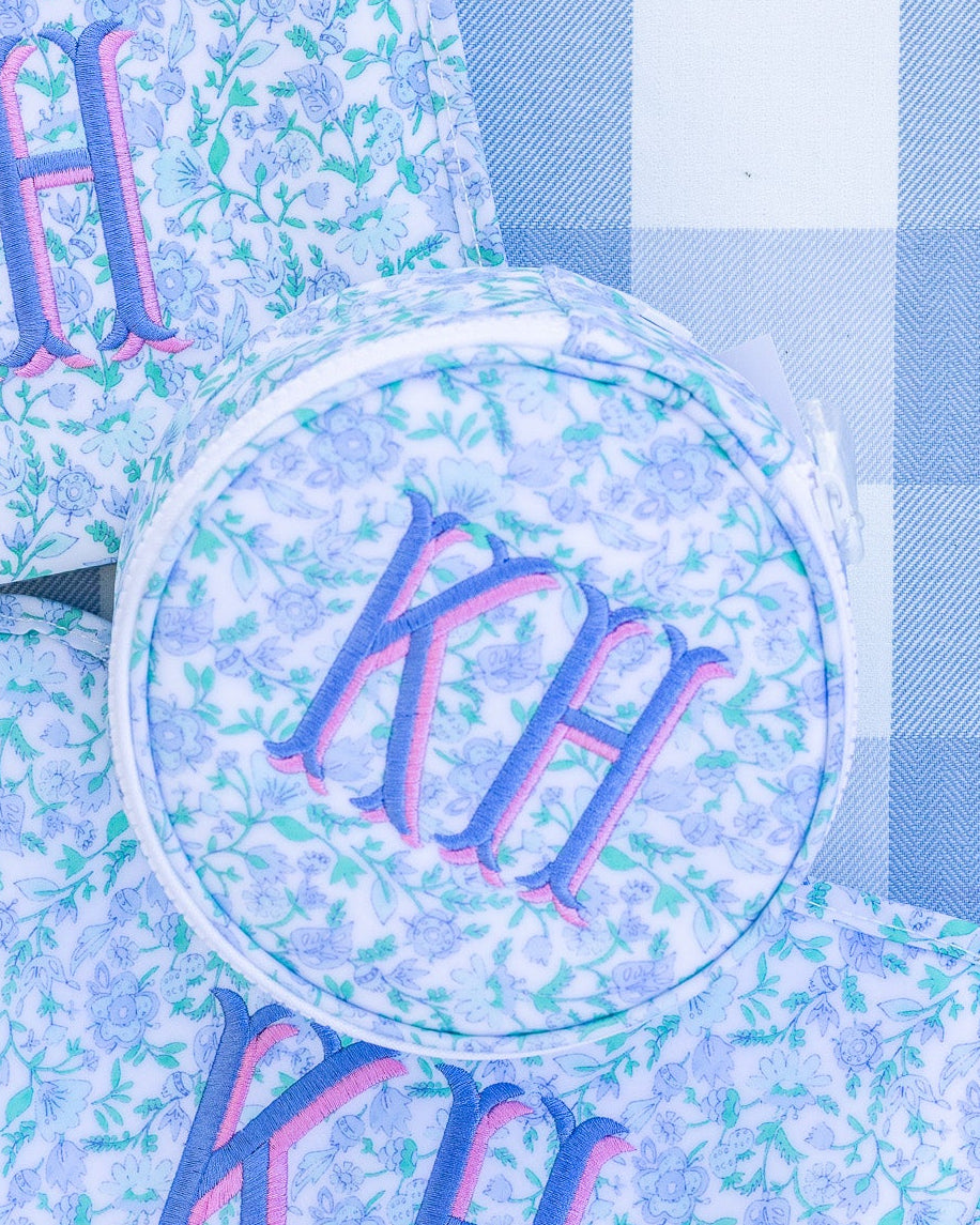 Three pouches with 'KH' monogram on a blue checkered background